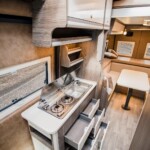 Le bloc cuisine se montre fourni en rangements : nombreux tiroirs, placards, porte-épices, range-chaussures, etc. Une tablette coulissante permet d'augmenter la surface de travail. Crédit ? MegaMobil