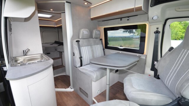 PÖSSL Summit Shine 640 R - L'ambiance intérieure - mélange de tonalités grise et bois, sublimée par de jolies lignes d'éclairages - est reconduite cette saison. Au salon, le placard de pavillon a été légèrement abaissé (8 mm) pour en faciliter l’accès.