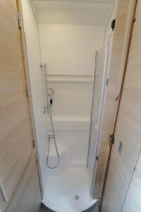 Lorsque l'on souhaite utiliser la douche, la penderie qui occupe l'espace vient pivoter au-dessus du lit. Dans le même temps, elle isole d'éventuels regards indiscrets à travers les baies arrière.