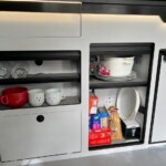 Des espaces bien compartimentés pour le matériel de cuisine et les petites réserves. Il faut composer avec les équipements techniques : convertisseur et vidange du chauffe-eau.