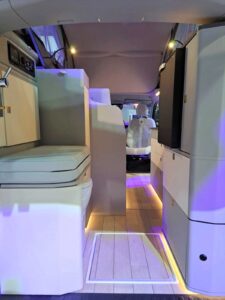 L'espace arrière concentre le WC à gauche, la douche au centre, frigo et rangements à droite.