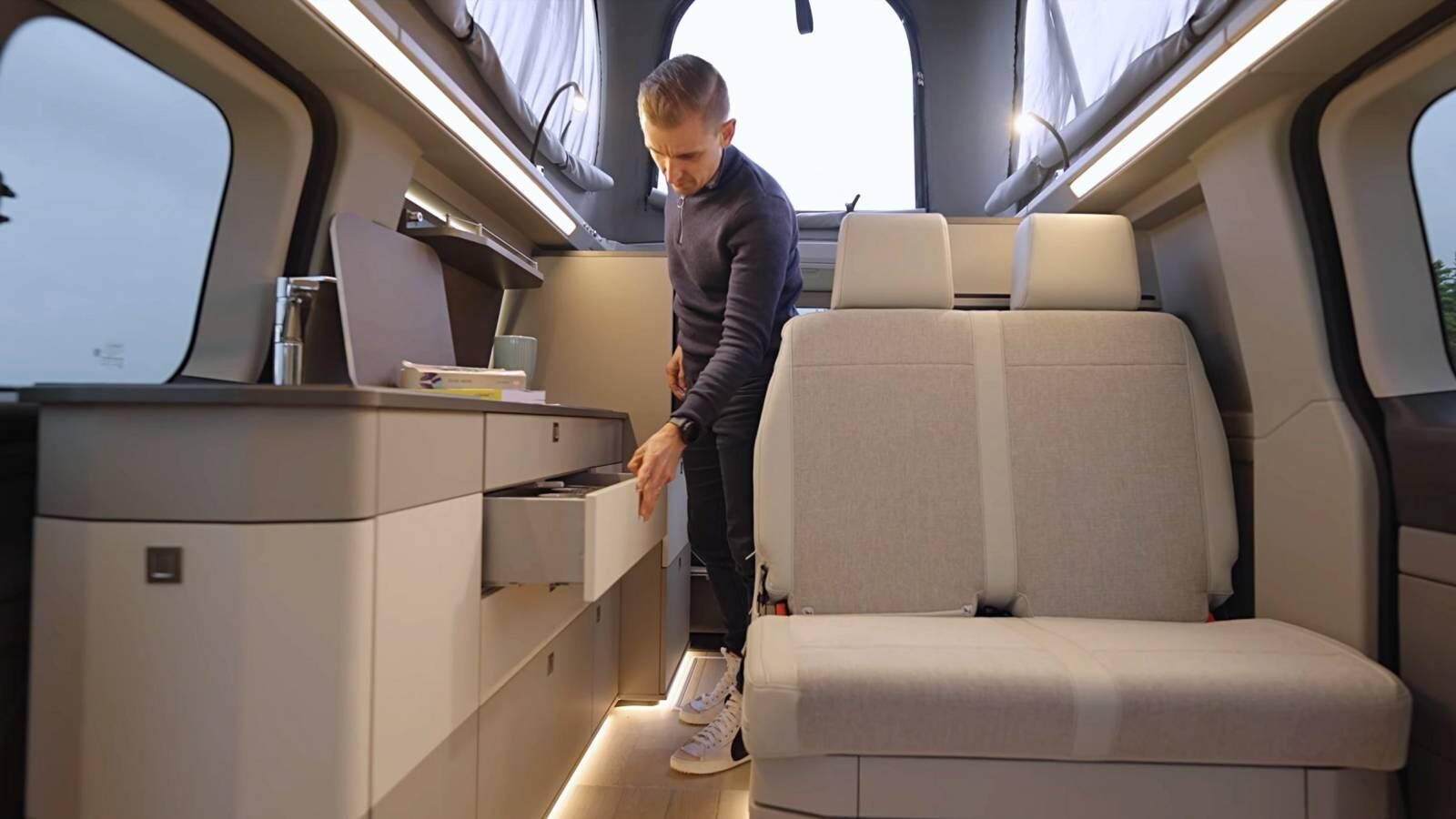 Ambiance intérieure chic et pratique à bord du Kelsey : mobilier aux formes biseautées, lumières et tonalités chaleureuses, rangements fonctionnels jusque sous la banquette.