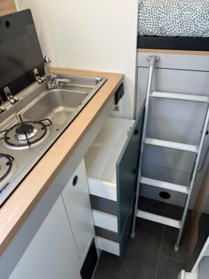 La position du lit transversal (120 cm du plancher) impose le recours permanent à l’échelle pliable, fixée au lit par deux pontets plastique, soumis à de fortes contraintes. Attention à la qualité des arrimages.