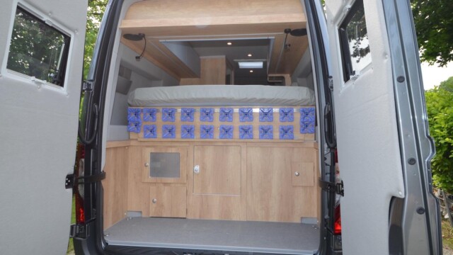 La soute ici libérée du coffre amovible et transformée en garage à vélos avec la tête de lit pliante relevée