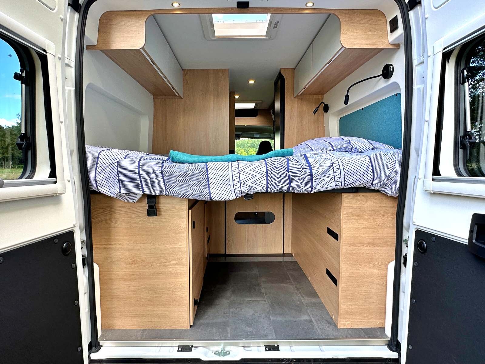 Le lit relevable dans sa partie centrale permet de dégager la zone arrière pour pouvoir stocker un vélo ou circuler la journée.