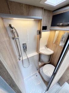 Une porte pivotante en verre acrylique isole la douche – robuste, facile d’entretien et fonctionnelle.