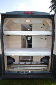 Deux échelles sont fournies, l'une pour accéder au lit haut à l'arrière et l'autre au toit relevable à l'avant. La douchette extérieure fait également partie des équipements d'origine.