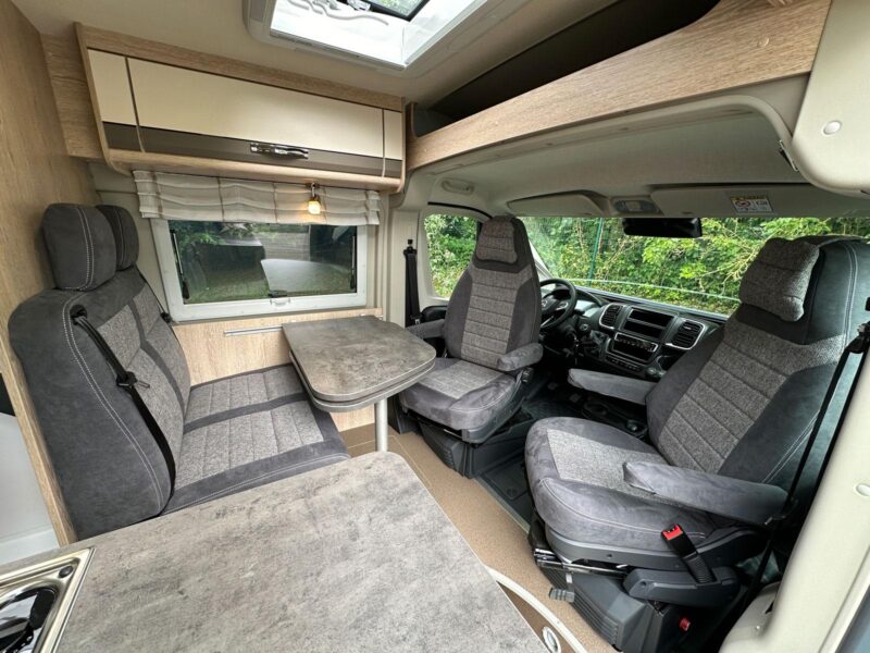 Pas de cabine ouverte pour le Summit 600 B Plus dans sa configuration de série. On continue de profiter d'un grand rangement au-dessus des sièges conducteur et passager. salon dînette fourgon Pössl Summit 600 B Plus