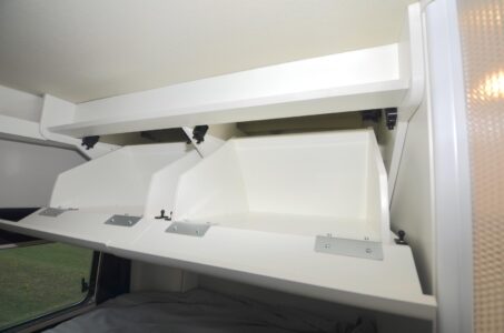 Une simple pression sur la façade permet ici de faire basculer l’ensemble du placard, monté sur de solides charnières.