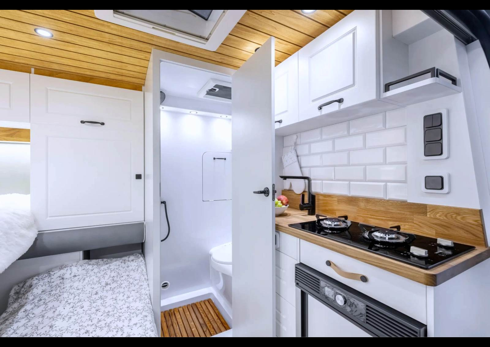 La cloison de séparation avec la cabine est un avantage pour l’isolation. La cuisine et le cabinet de toilette s’y adossent et profitent de profonds rangements au-dessus de la cabine.