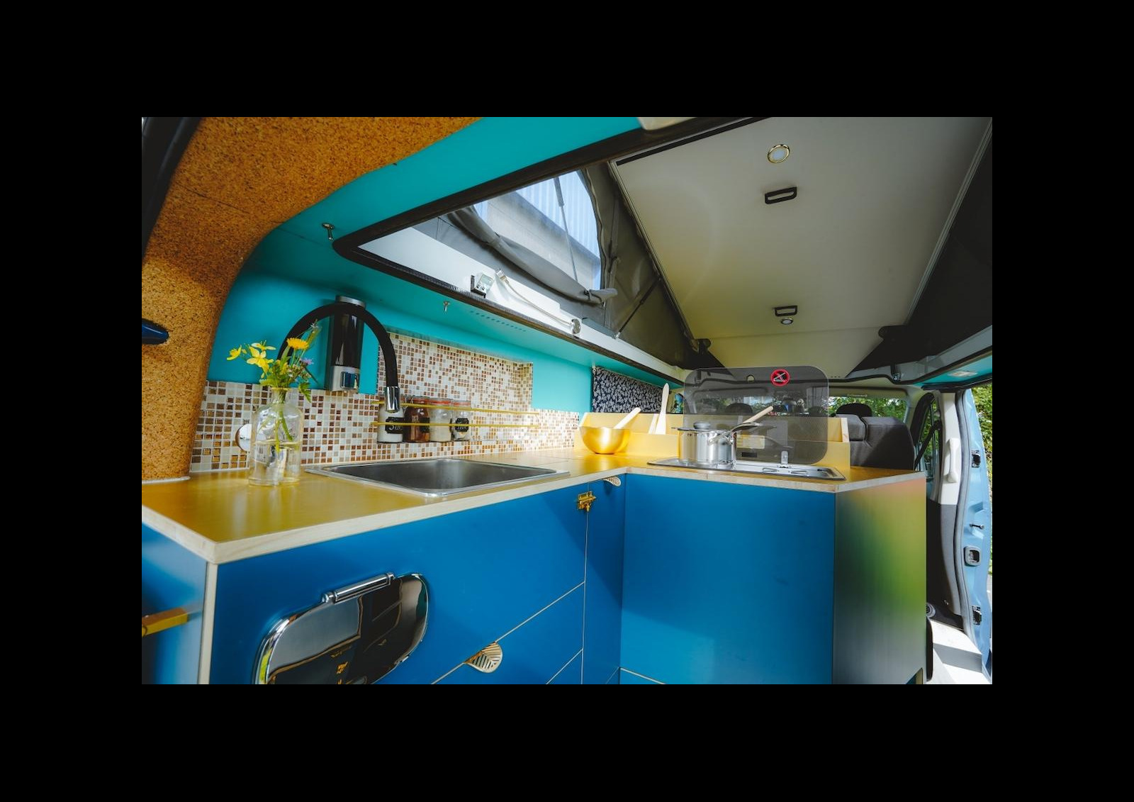 Le Tiny 5 propose un agencement inspiré du Ford Nugget, avec une cuisine en L à l'arrière et un toit à ouverture arrière. Les photos intérieures sont ici celles du prototype (quasi similaire au modèle d'expo). © Voilacam