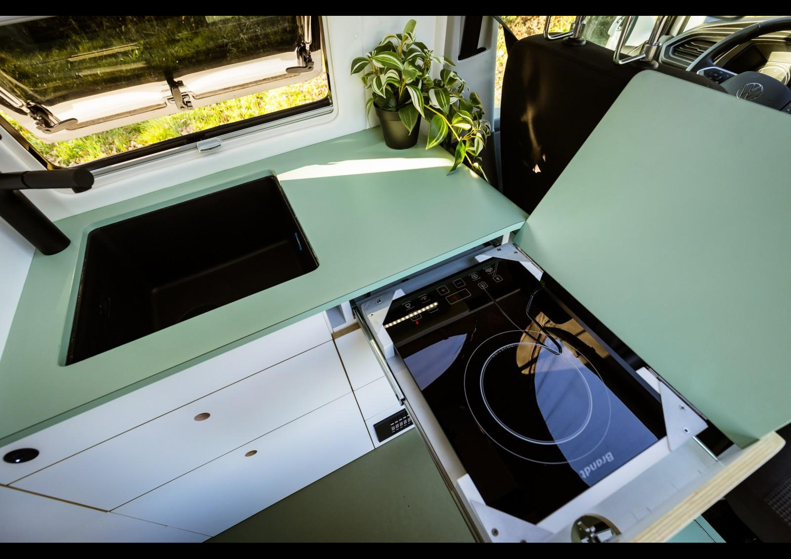La plaque de cuisson à induction se loge dans un tiroir. Un abattant permet ici d'accroître la surface de travail disponible. Crédit ? Arnold d'Hostel