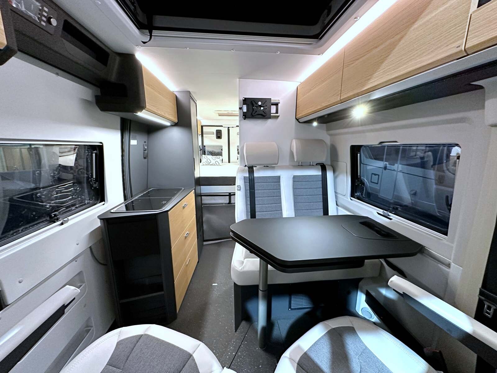 L'ambiance et le design intérieurs composent un ensemble harmonieux : contraste de couleurs, parois claires, surfaces noires, portes des placards et des tiroirs en finition bois.