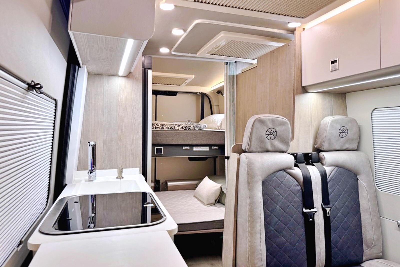 Design moderne et fonctionnel, les meubles sont en finition bois gris frêne, associé à des portes blanches et un revêtement de sol clair.