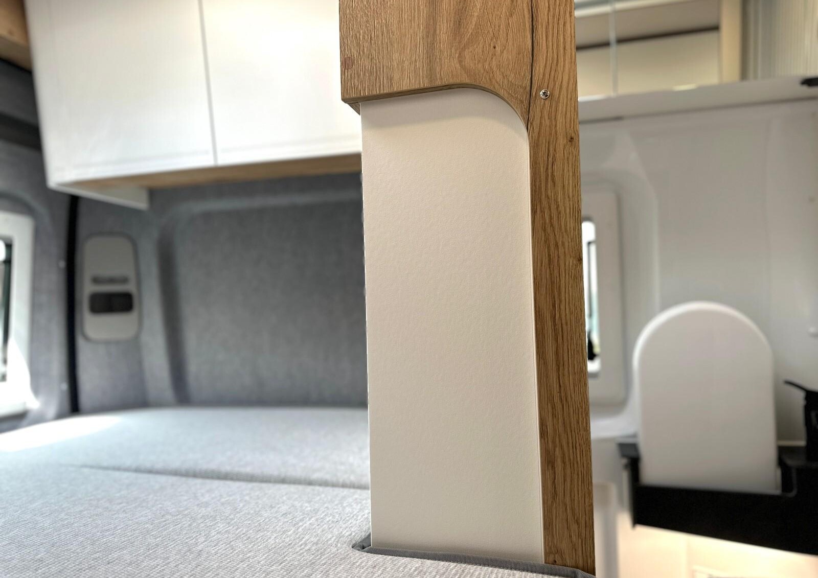 Clever Vans Tour 540 - En configuration jour, la paroi vient empiéter sur le lit.