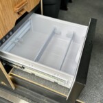 En partie basse du meuble, le frigo 12V à compression s'ouvre comme un tiroir.