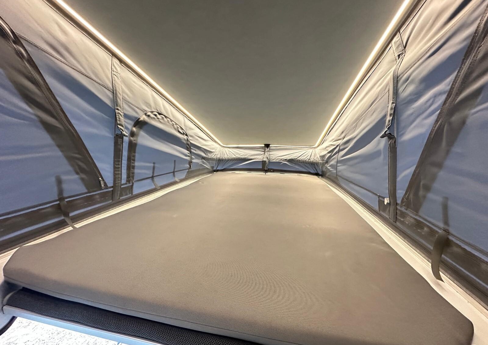 Dans la chambre haute, un éclairage ceinture le ciel de toit.