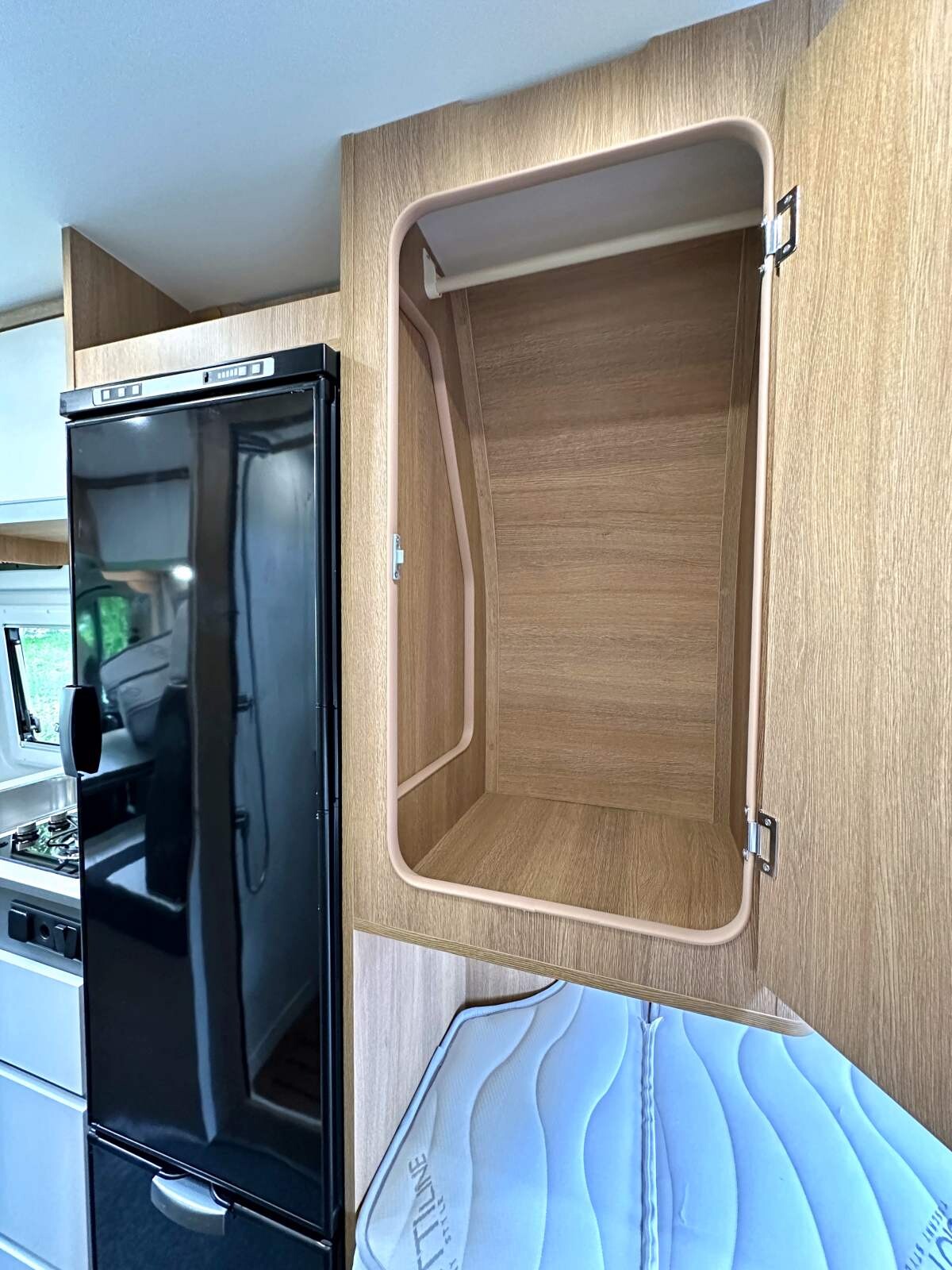 Une penderie profonde jouxte le frigo au dessus du lit jumeau droit.