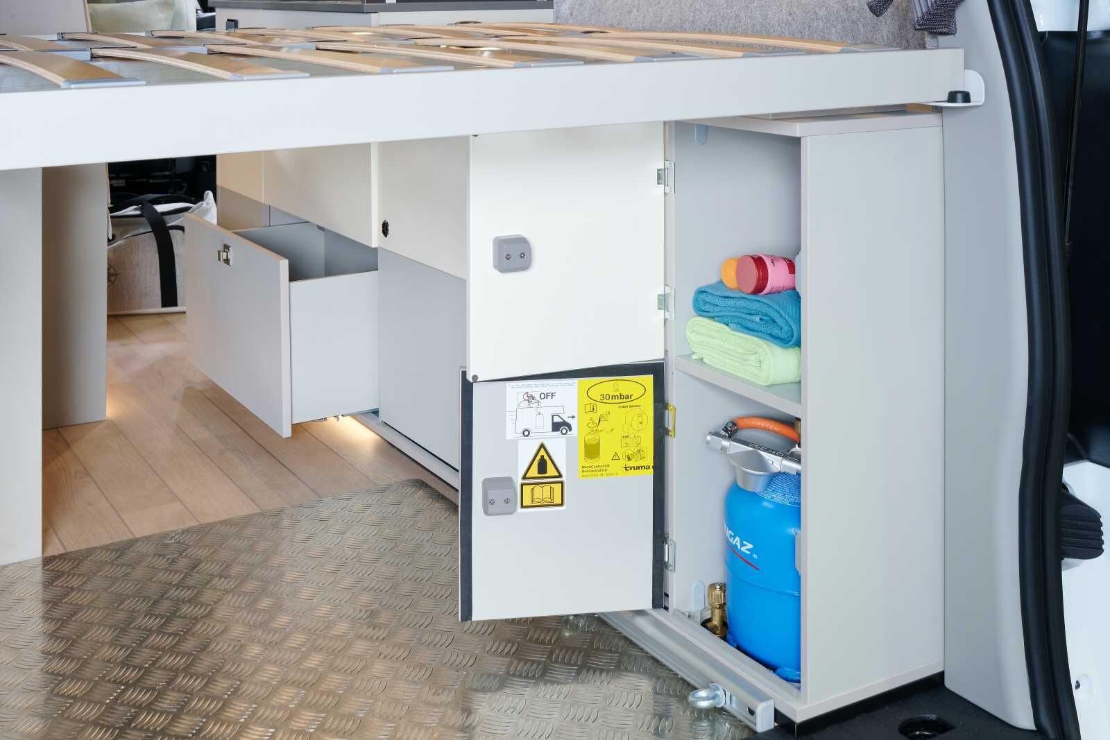 Le mobilier latéral droit accueille des rangements ainsi que le coffre à gaz pour alimenter le réchaud de la cuisine.