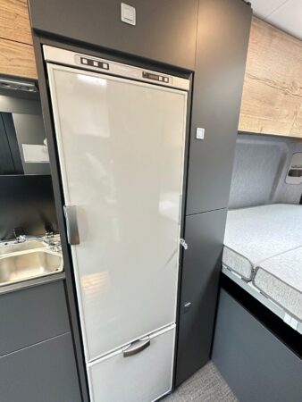 CleverVans Celebration 600. Frigo colonne 138 l. On conserve tout de même deux espaces de rangement à droite du réfrigérateur. Frigidaire fourgon CleverVans Celebration 600