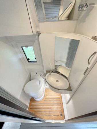 Clever Vans Celebration 600. Cabinet de toilette Vario. La pario du lavabo pivote au-dessus du W.-C. pour libérer la douche. Cabinet de toilette vario fourgon CleverVans Celebration 600