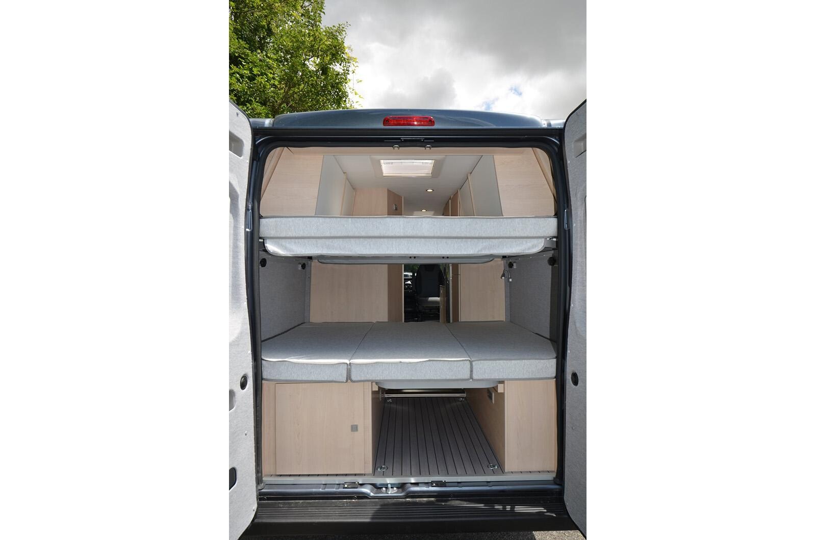 CleverVans Vario Kids 600. Dans cette configuration (lit du haut + placard de pavillon), de jeunes enfants peuvent dormir dans la longueur du lit du haut. fourgon CleverVans Vario Kids 600 soute