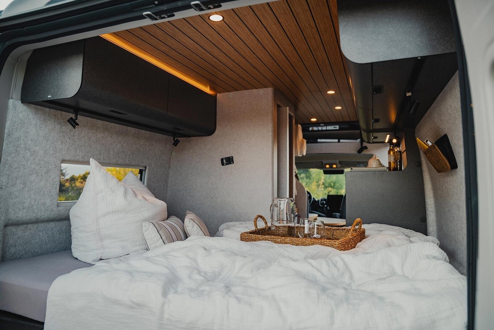 Hymer Redwood. Parois habillage textile, sommier à coupelles et dimensions généreuses du lit (157/150 x 195 cm), le confort est au rendez-vous dans le chambre. Chambre lit transversal fourgon Hymer Redwood
