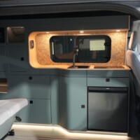 Aménagement "New Ultimate" by Rhön Camp : on note les jolies courbes du meuble latéral comprenant la cuisine fixe.