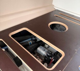 Espace technique en pied de lit. Réservoir d'eau + pompe. fourgon aménagé Renault Trafic