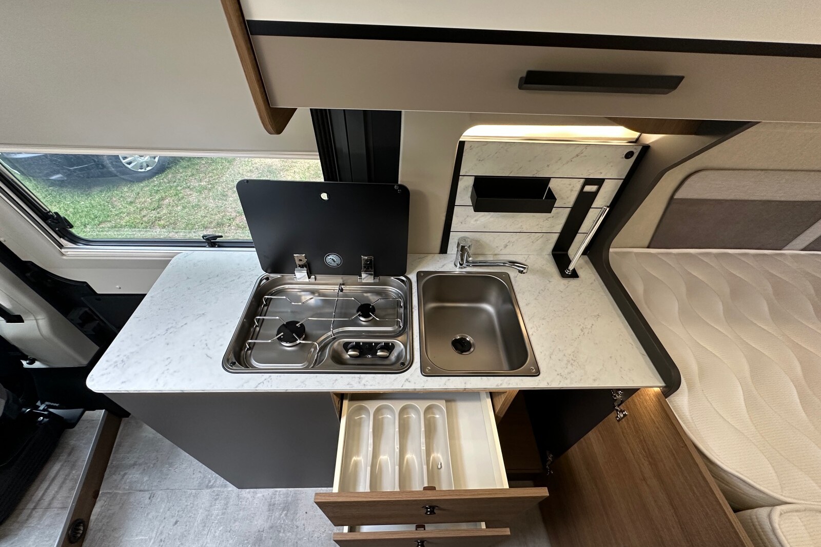 BENIMAR Benivan 160 Plus - Le bloc cuisine conserve de petites surfaces de travail de part et d'autre de l'évier et des plaques de cuisson.