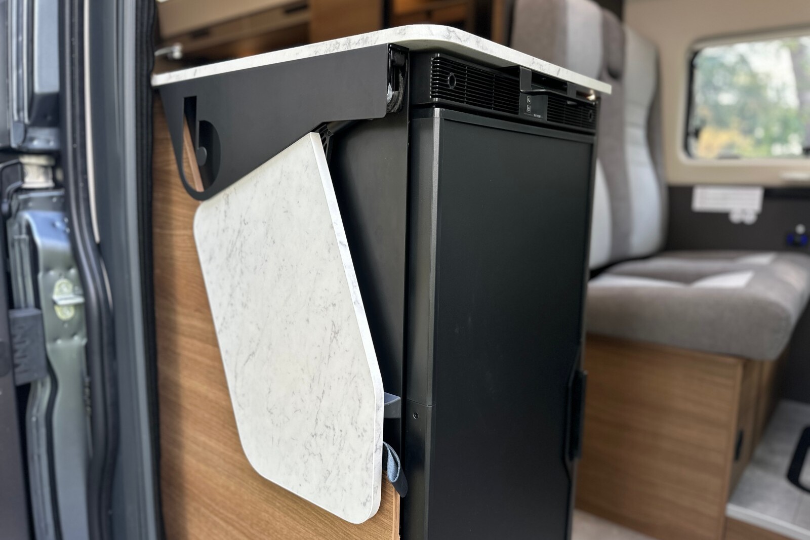 BENIMAR Benivan 160 Plus - Malgré l'intégration du frigo en bout de meuble, une tablette escamotable reste disponible au dos du bloc cuisine. Pour la mettre en place, il suffit de la tirer vers le haut, puis de la faire basculer dans le prolongement du plan de travail.