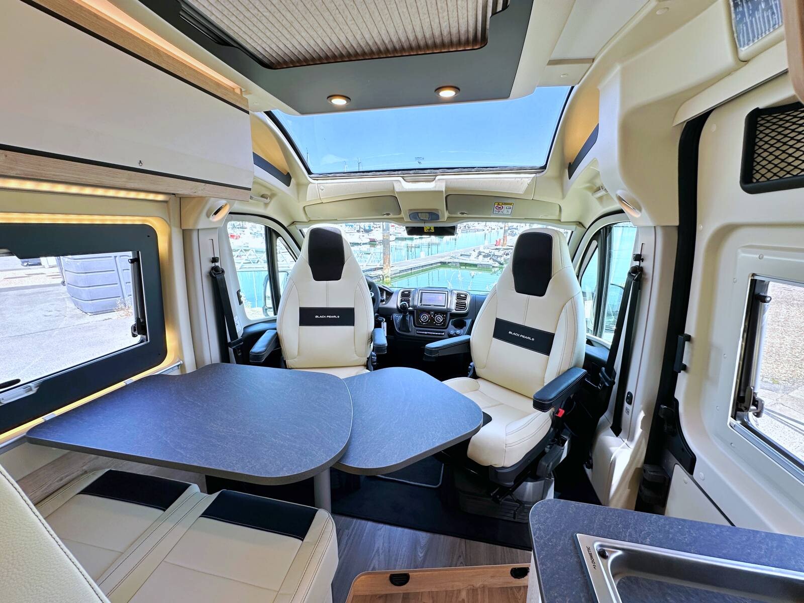 La table dinette peut être utilisée à l'extérieur du fourgon, fixée à un rail à l'arrière du meuble cuisine.