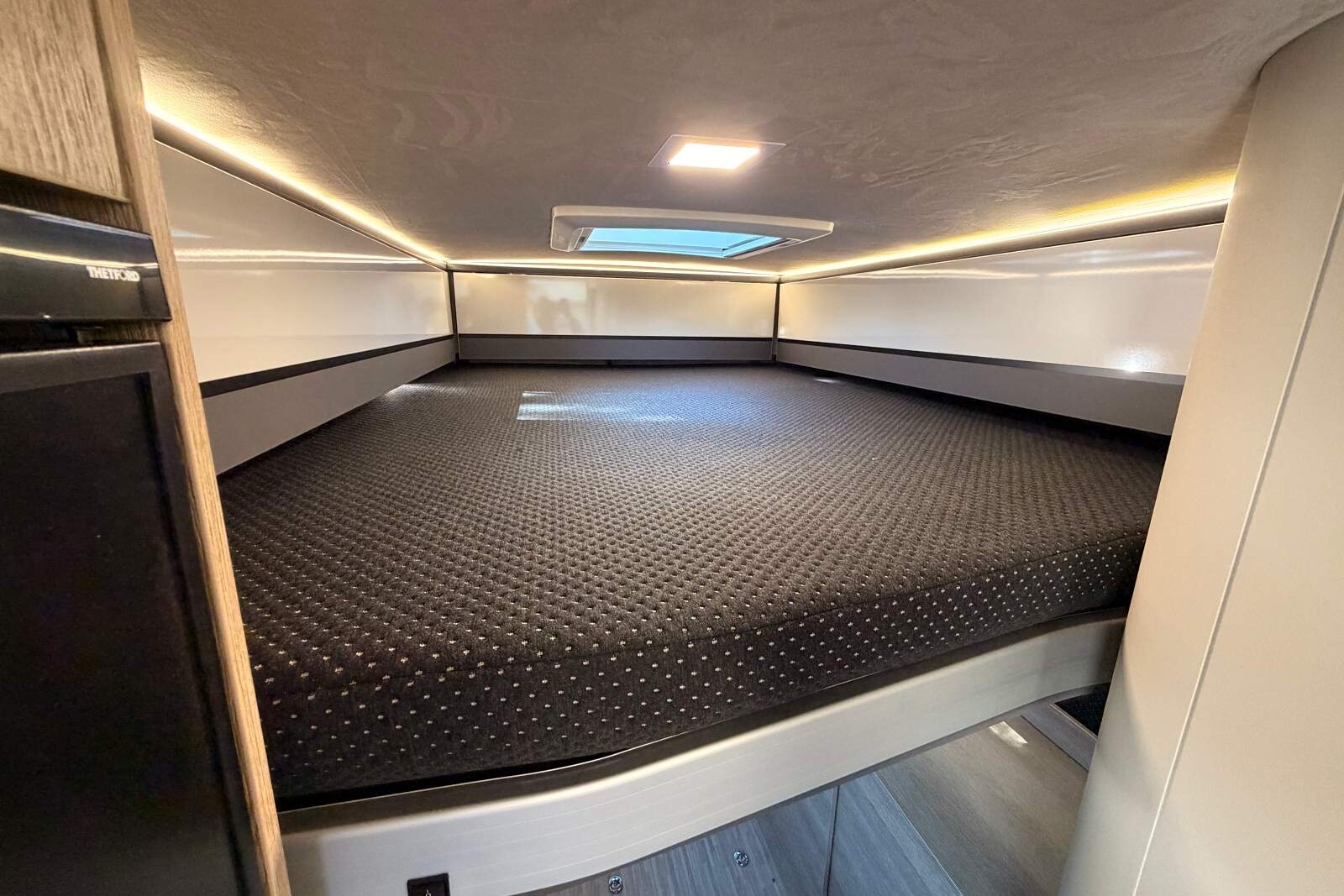Position haute du lit. Le matelas d'une seule pièce ne permet pas de le monter plus haut. fourgon camping-car eden camp