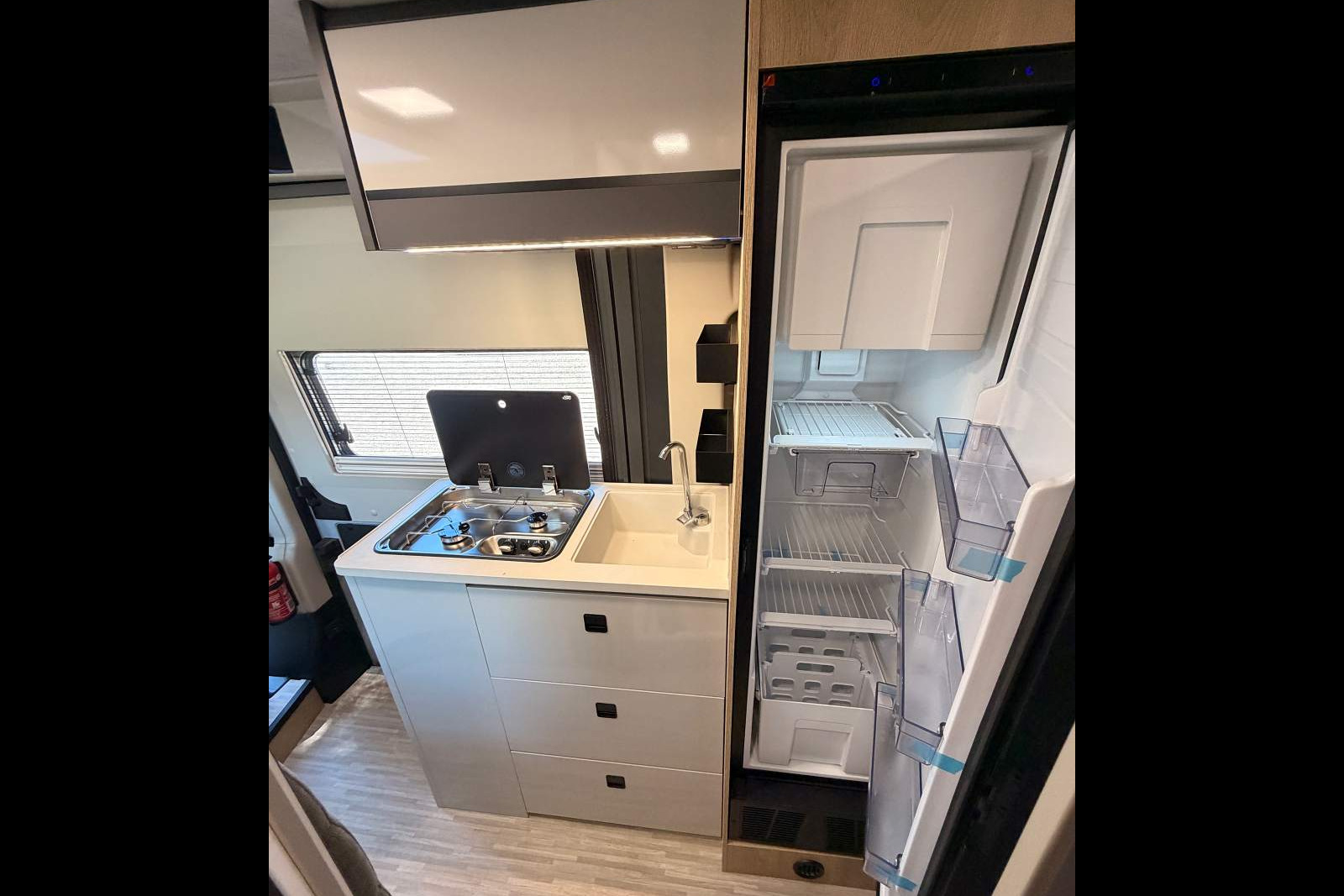 Frigo à compression de 138 L., dont un large compartiment conservation. fourgon camping-car eden camp