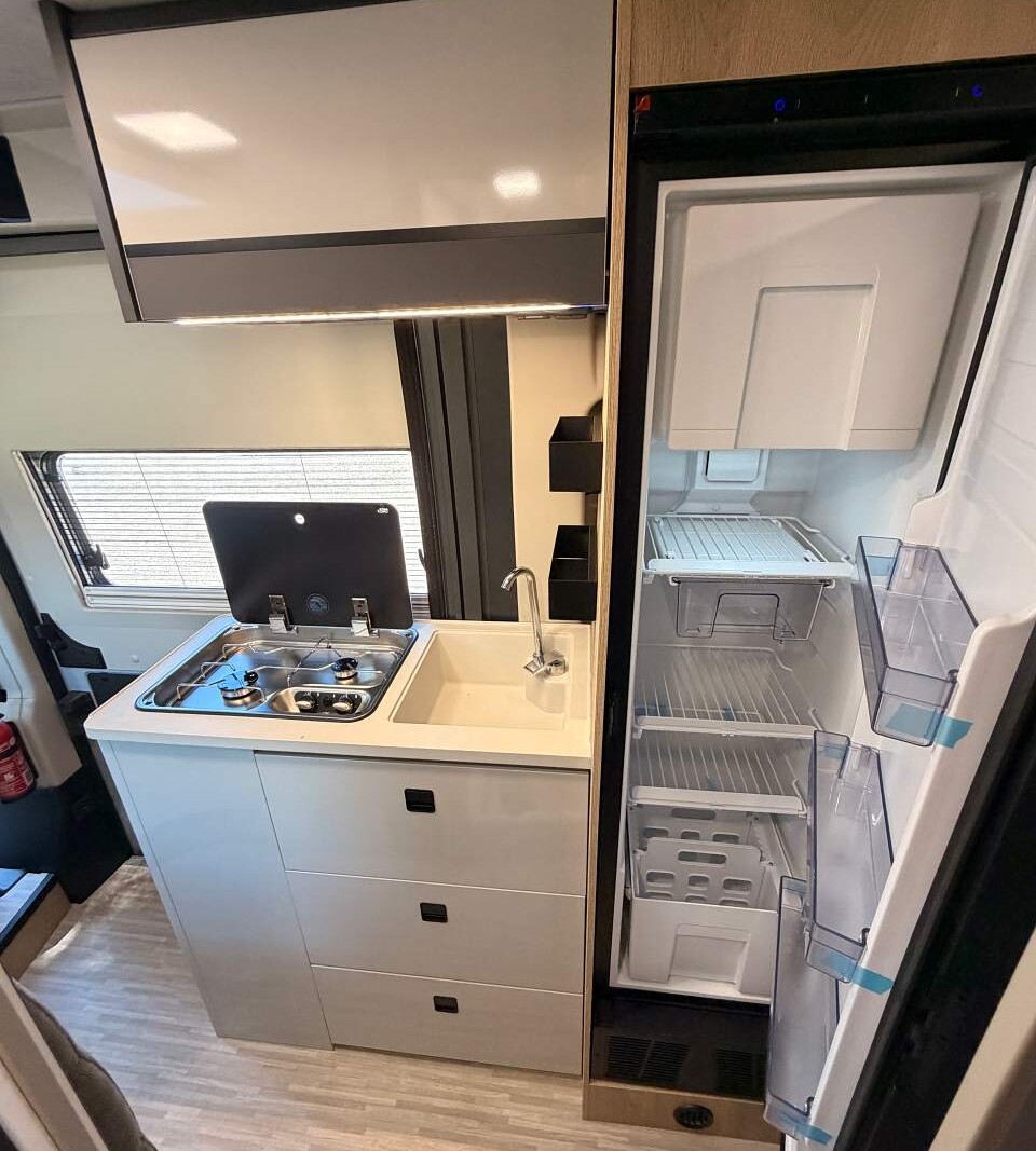Frigo à compression de 138 L., dont un large compartiment conservation. fourgon camping-car eden camp